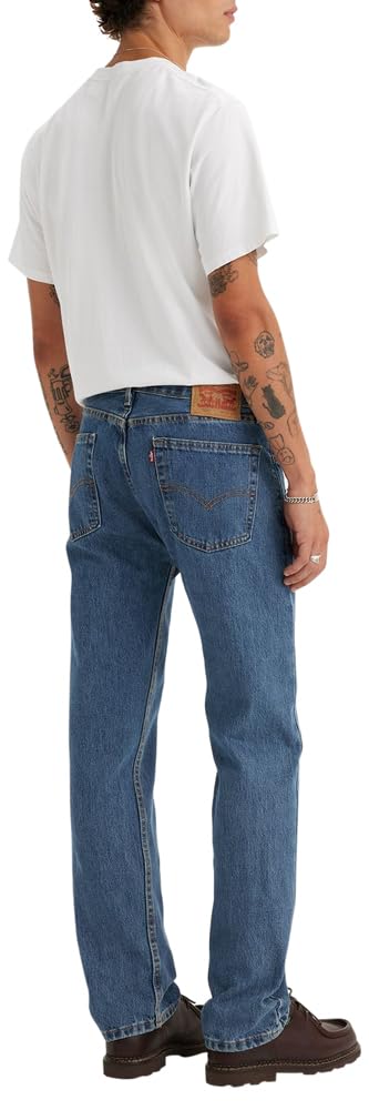 Men's 505 regular fit jeans in faded blue, worn look with a model standing against a plain wall