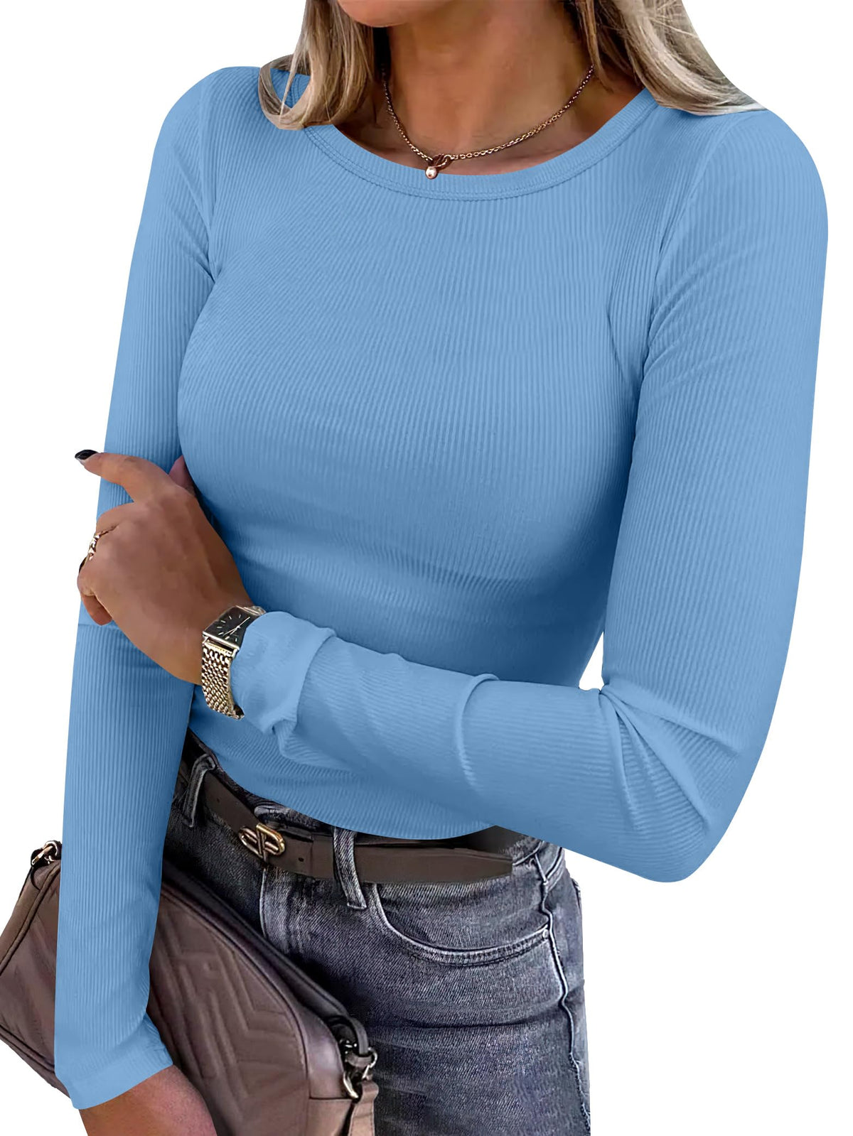 Model wearing the long sleeve ribbed fitted top tucked into trousers