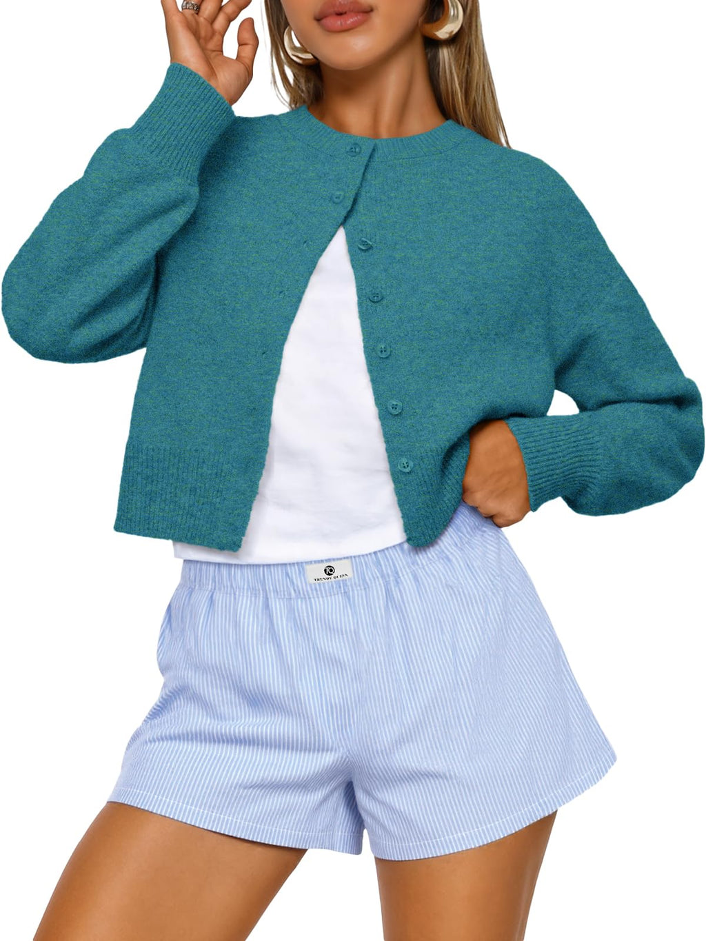 Model wearing the cropped cardigan buttoned with hands in pockets