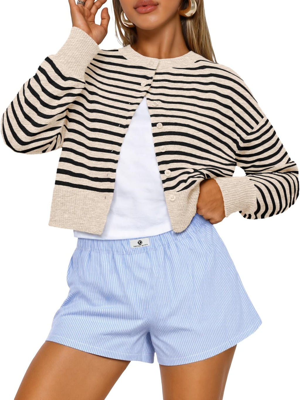 Cropped cardigan layered over a long-sleeve top for cool-weather styling